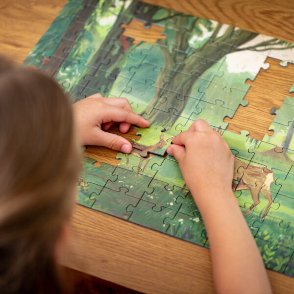 Puzzle dla dzieci, dla kochających przyrodę, las i zwierzęta leśne. Na ilustracji polski las, w wiosennej aurze, wszystko rodzi się do życia po zimie. Sarna opiekuje się swoimi koźlętami, na drzewach widać wiewiórki pospolite, dzięcioła zielonego, a w ściółce ryjówkę aksamitną.
