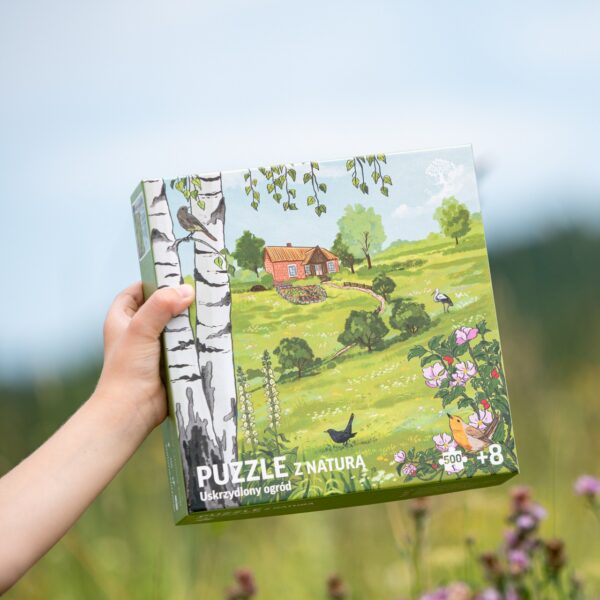 Puzzle z polską przyrodą, na ilustracji bocian biały, rudzik, kos, pliszka siwa, kopciuszek zwyczajny i typowa wiejska zabudowa, z sadem i ogrodem warzywnym.