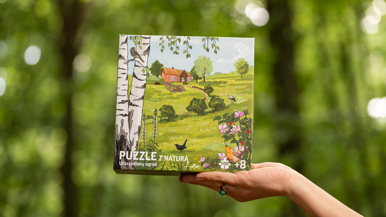 Puzzle z polską przyrodą i krajobrazem wsi. Na ilustracji wiejski dom tradycyjny, z przydomowym ogródkiem, sadem i łąką. Ptaki na ilustracji: bocian biały, kos, pliszka siwa, kopciuszek zwyczajny, rudzik.