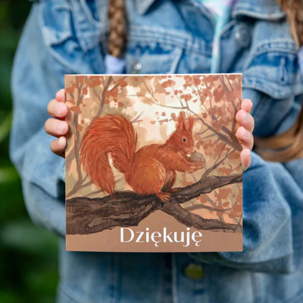 Kartka okolicznościowa, polska firma, z napisem "Dziękuję", na ilustracji wiewiórka pospolita na drzewie, wśród liści. Kartka kwadratowa.