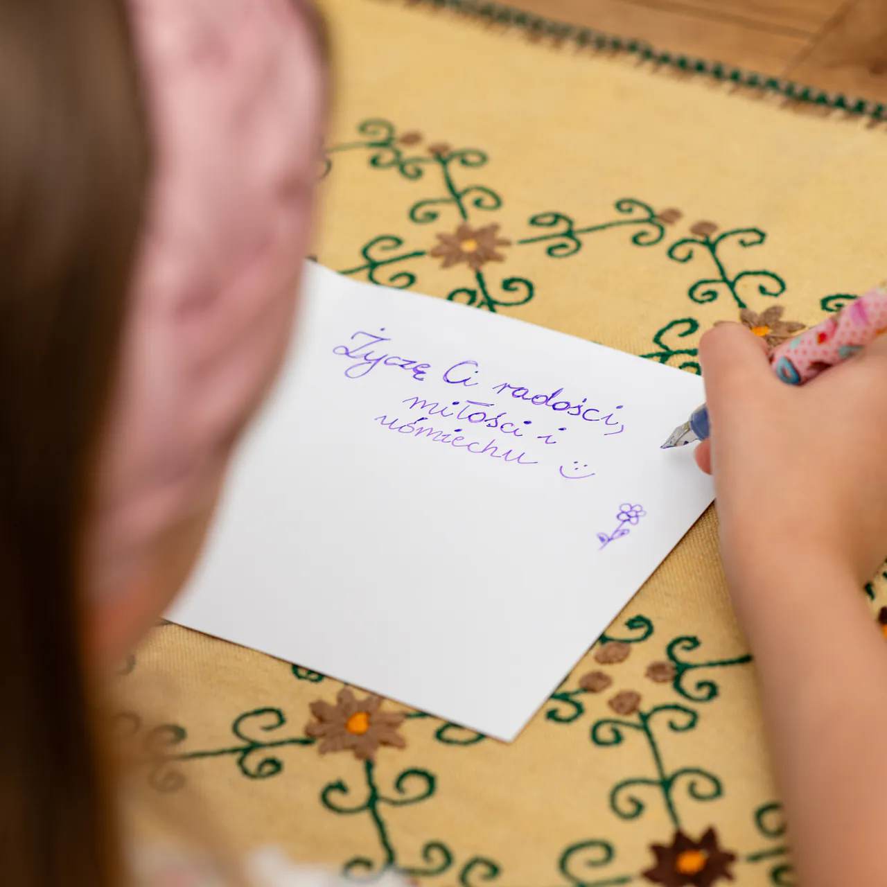 Kartka okolicznościowa z możliwością wpisania osobistej dedykacji, od serca lub wiersza, cytatu o konkretnym znaczeniu. Na zdjęciu wpisywaniem piórem osobistej dedykacji z podziękowaniem i słowem Życzę Ci.